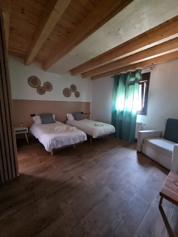 Habitación principal con dos camas y sofá