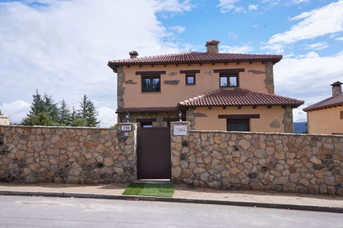 La casa vista desde el jardín, con la terraza y la barbacoa